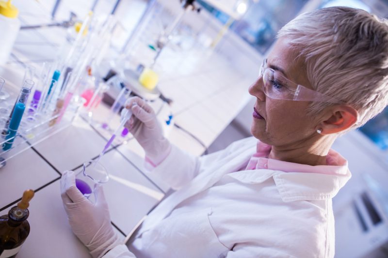 Mature female chemist working on scientific experiment in the lab